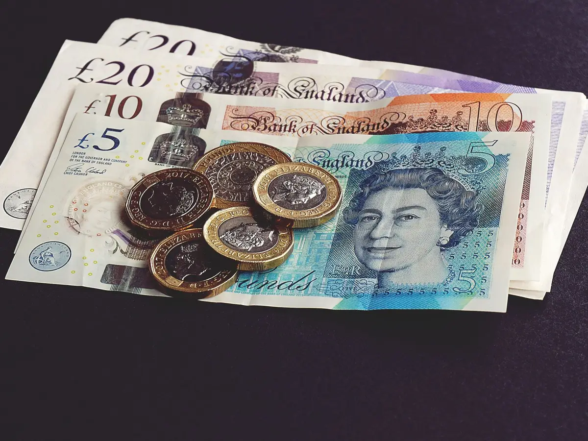 British pound notes and coins on a dark table