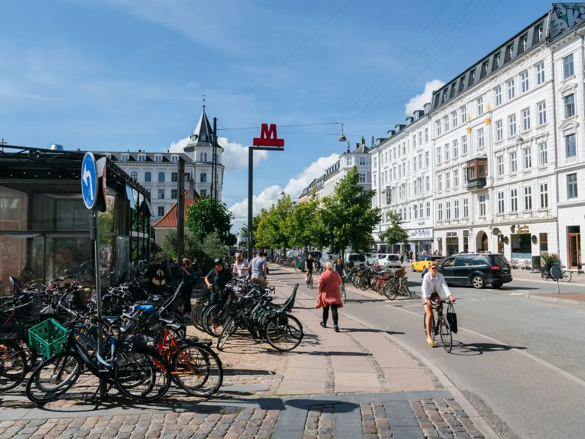 Cyclists and parked bikes on a busy Copenhagen street
