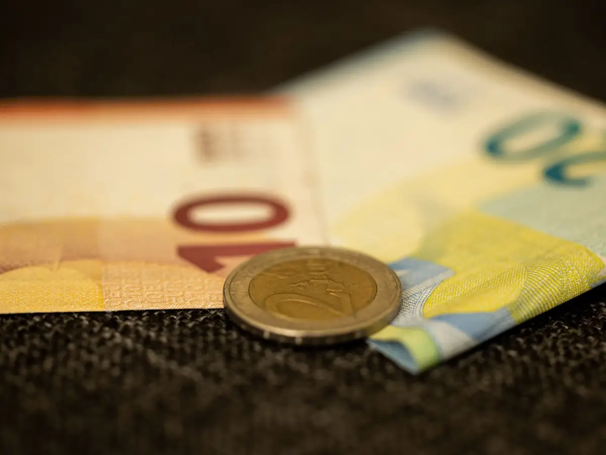 Euro banknotes with a 2-euro coin on top