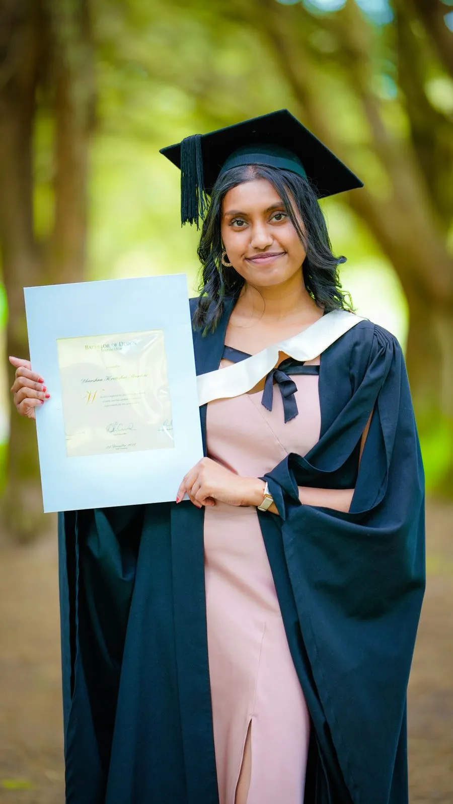 Prakriti, a Nepali nursing graduate in cap and gown, holding her degree certificate