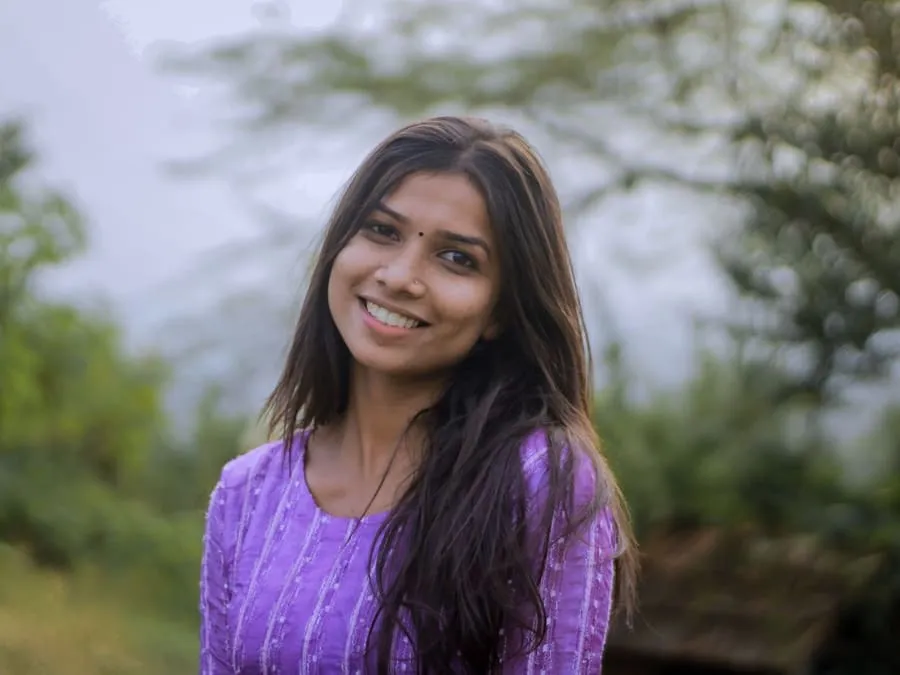 Sujata smiling outdoors in a purple kurta