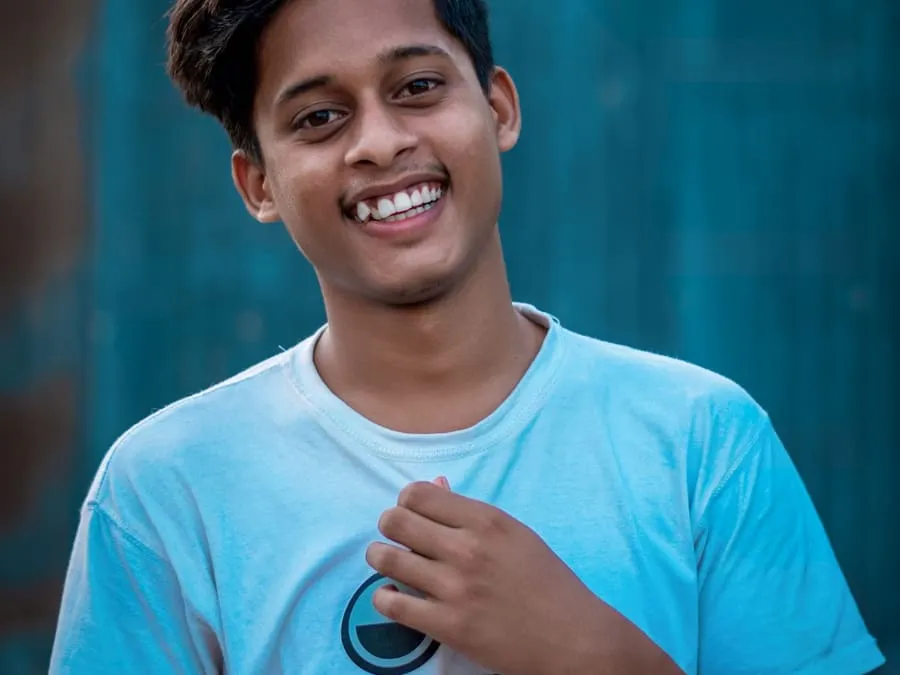 Manoj smiling in a light blue t-shirt