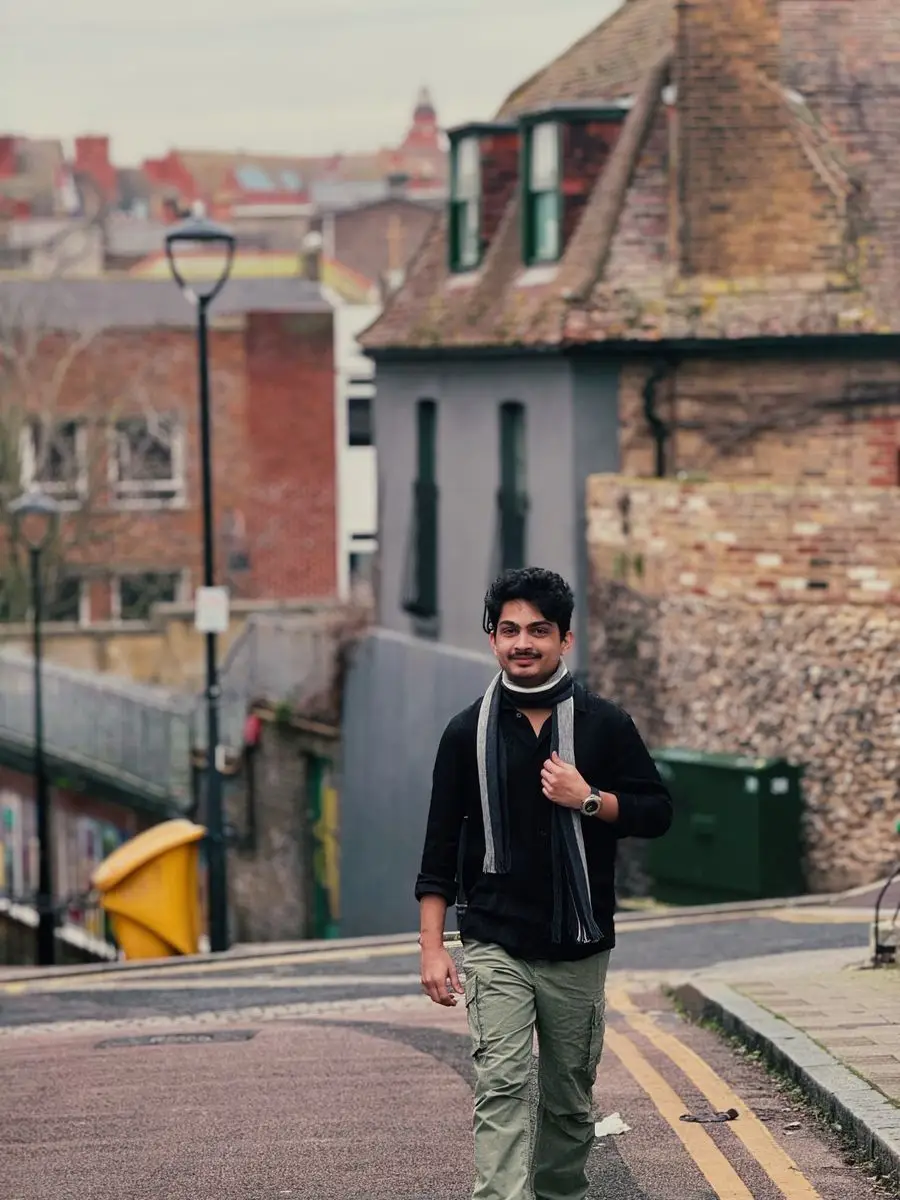 Aayush walking down a street of old buildings in Germany