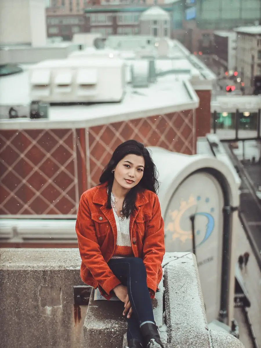 Sneha on a snowy rooftop above a Swedish city