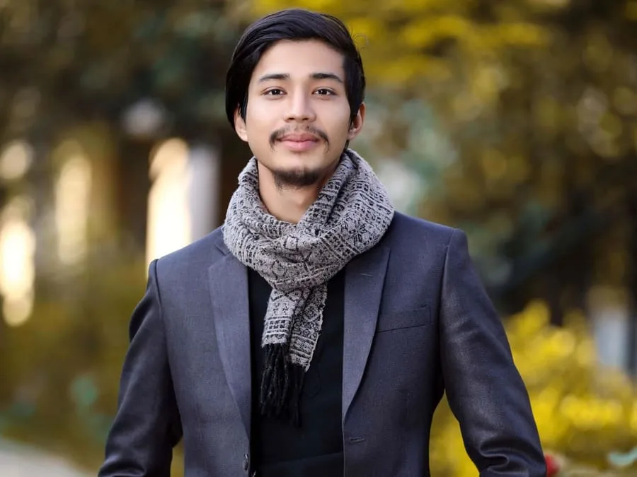 Ankit in a blazer and scarf, smiling outdoors